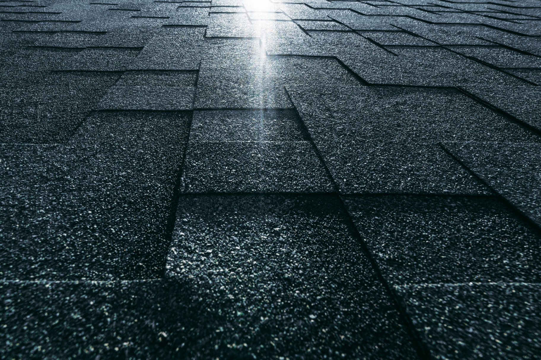 Detail shot of dark architectural shingles with mineral granules