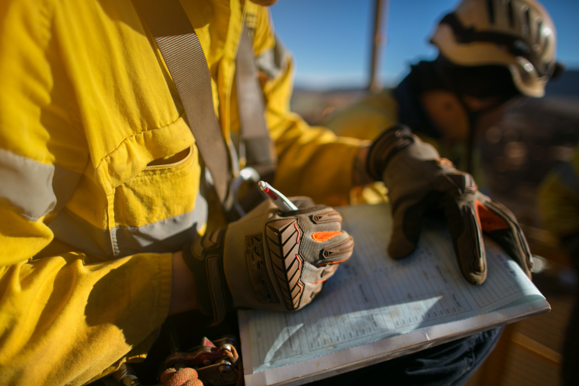 Retro Roofing inspector in a high-visibility jacket documenting findings on a clipboard