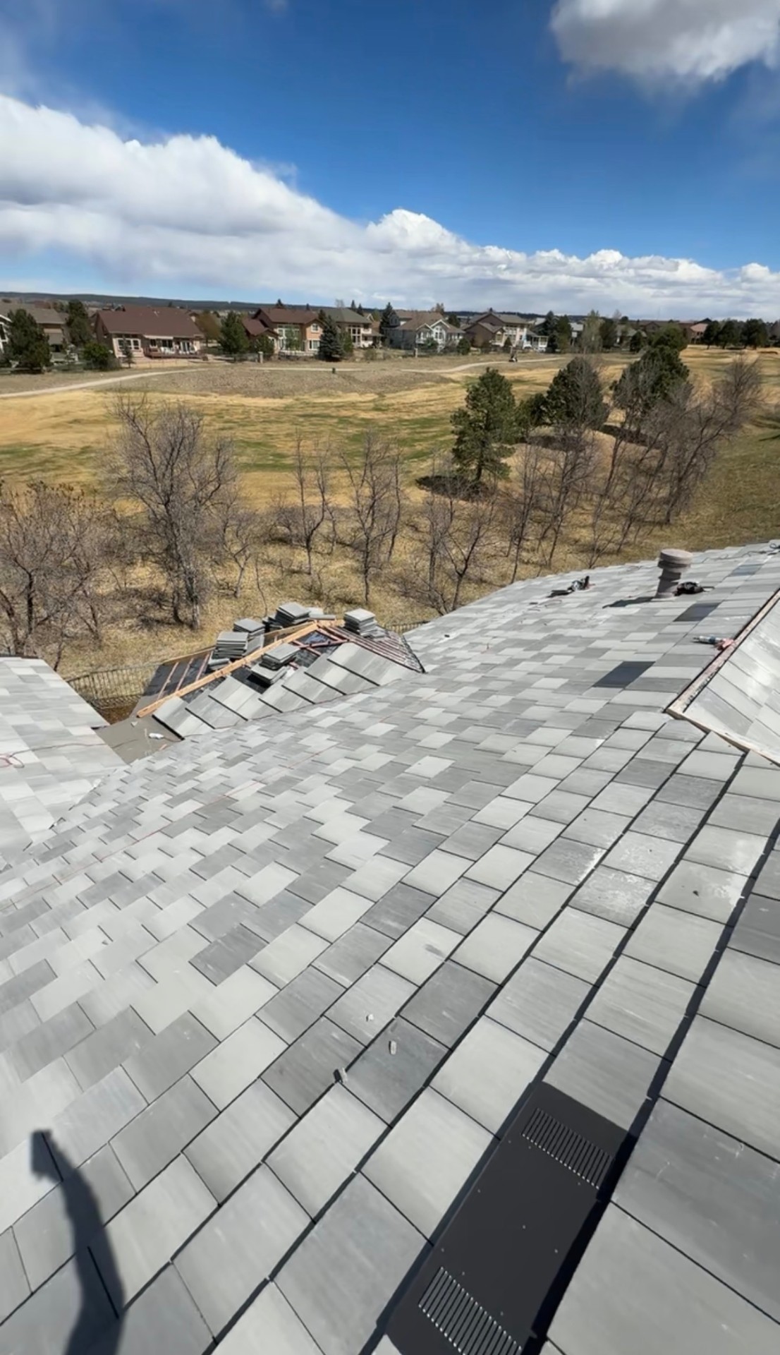 Specialty tile roof in progress overlooking open Colorado field