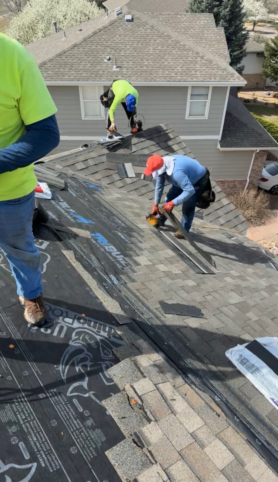 Retro Roofing crew tearing off shingles on a residential roof